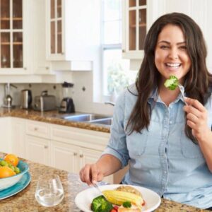 A woman sitting at the table eating food.