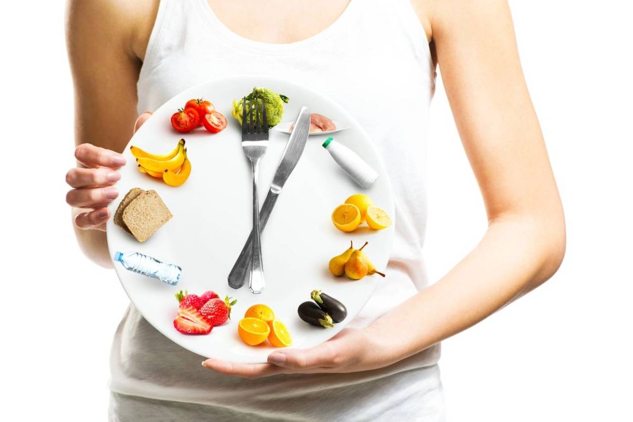 A woman holding a plate with food on it.